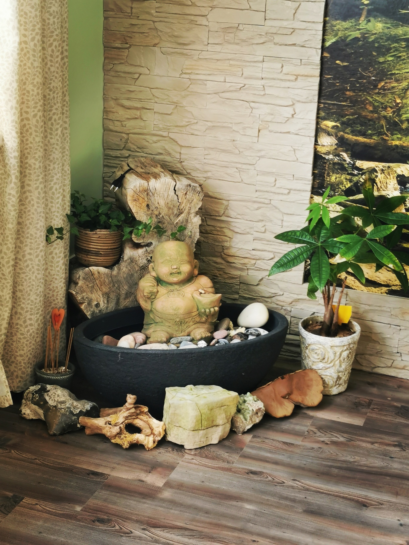 Ruheecke in der Praxis Raum für Möglichkeiten mit Zimmerbrunnen, Buddha-Figur, Steinen und Pflanzen